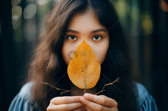 手持叶子的女子图片