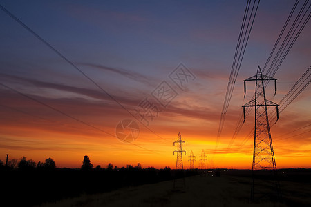 日落时户外的高压塔背景图片