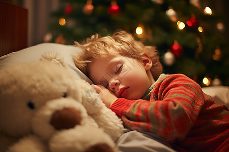 玩具熊旁入睡的男孩图片