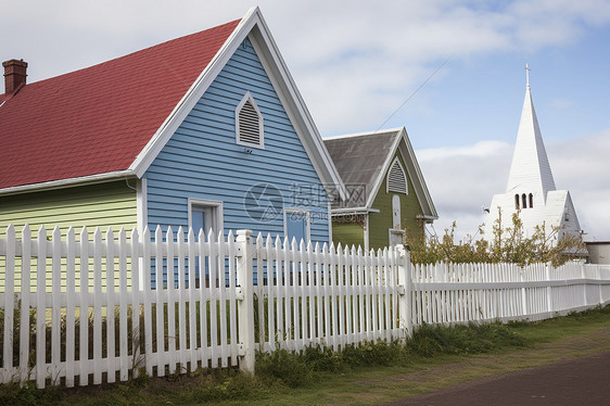 白栅栏旁的蓝屋红顶图片