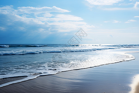 海浪冲刷着蓝天白云下的沙滩图片