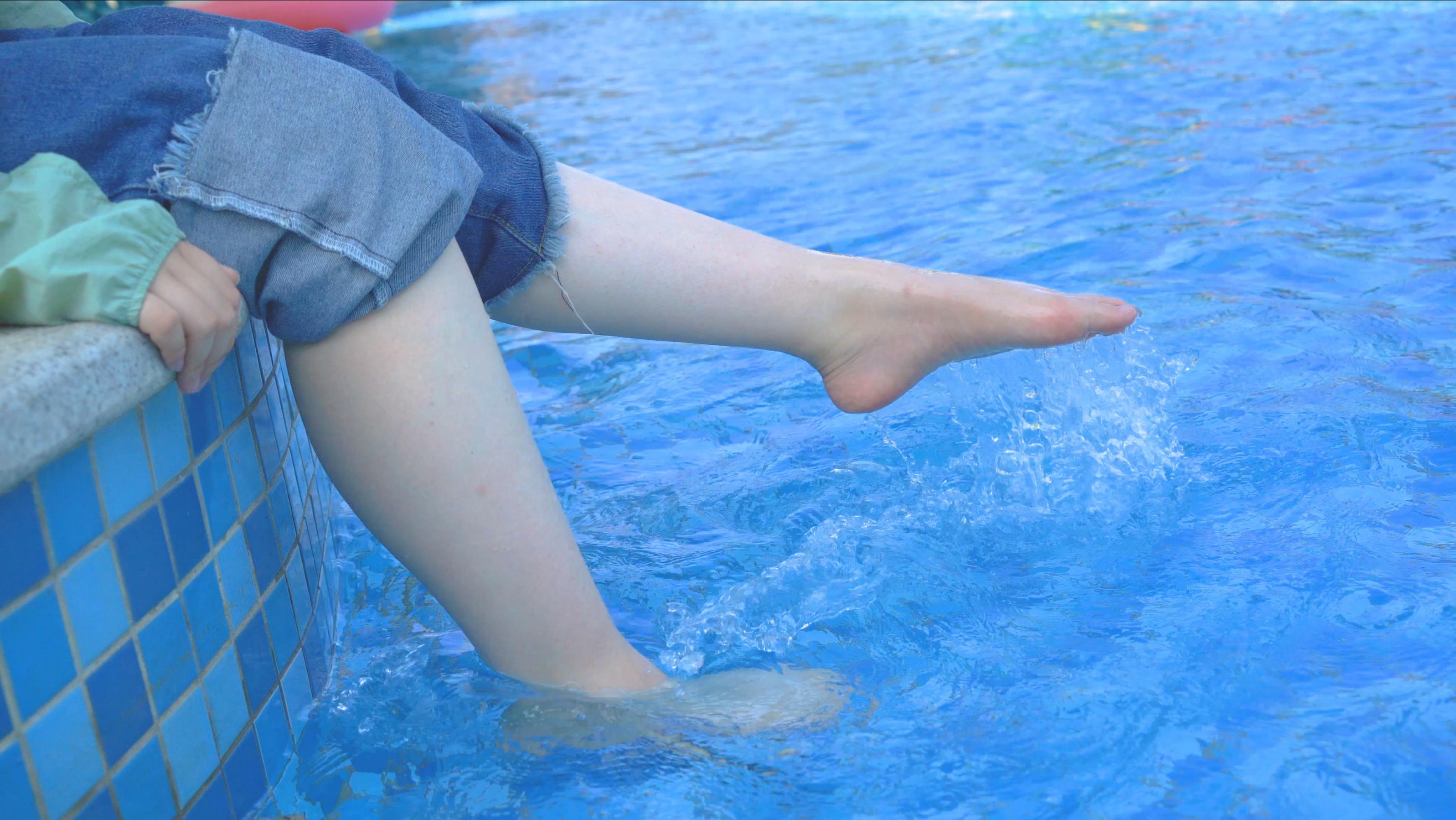 4k女生坐在台阶上踢水