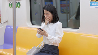 女孩坐地铁玩手机困意袭来视频素材