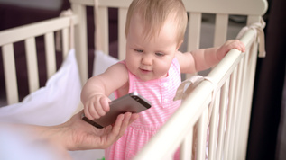 婴儿床小可爱触摸智能手机婴儿技术概念视频素材