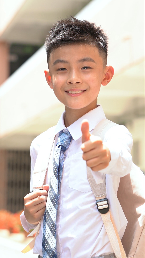 校园背书包的小学生竖大拇指点赞