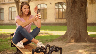 青年女子在大学附近手机聊天视频素材