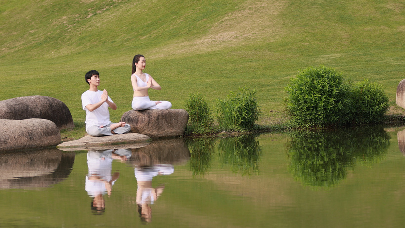 男女生河边盘坐双手合十合实