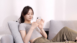 女性在沙发上玩手机视频素材