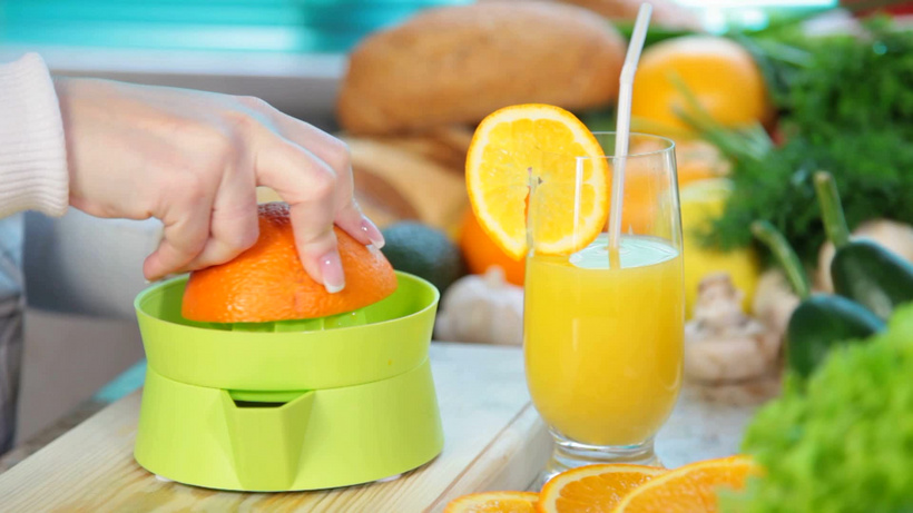 女性手在榨汁机上挤压橙汁                        id:138759