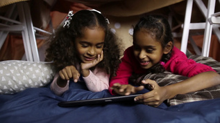 两位小女孩在数字平板电脑上学习视频素材