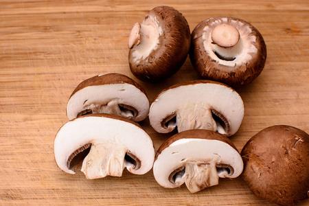 灰色的蘑菇香菇躺在木制厨具板