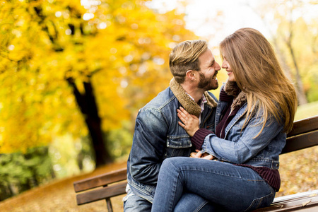 年轻爱夫妻在秋天的公园