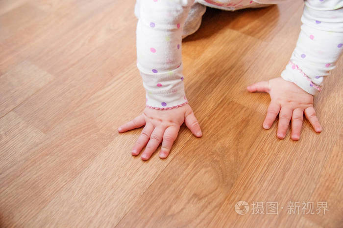 宝宝爬在公寓的地板上一个小的孩子学会爬行和走路