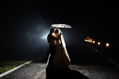 幸福的新娘和新郎夜晚用的伞