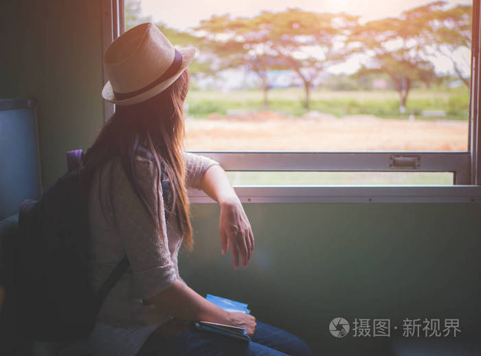 年轻漂亮的女人坐坐在窗边看着窗外的经典火车旅行