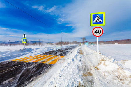 汽车行驶时的危险雪道。冬季, 大雪, 暴风雪, 风雪, 道路上的能见度差, 公共汽车站和路标在农村