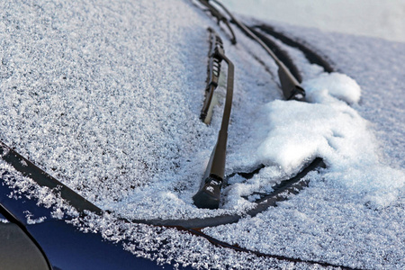 在道路交通中的冬天。一辆汽车的挡风玻璃上的冰和雪