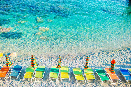 日光浴浴床和遮阳伞在美丽的欧洲海滨，在意大利的五渔村，利古里亚在蒙泰罗索