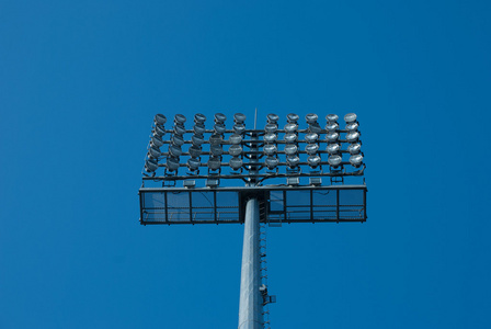 泛光灯。蓝色的天空映衬的体育场照明。riflettore