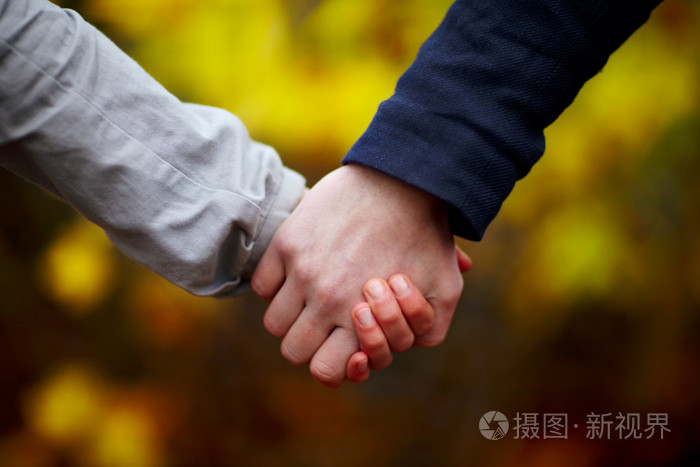 恋爱中的情侣在秋天牵手