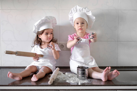 快乐家庭的有趣的孩子们正在准备面团 烤饼干在厨房里