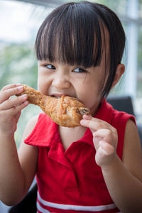 亚洲女孩享受茶亚洲的中国小女孩吃炸鸡照片
