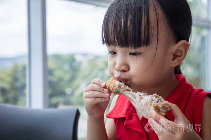亚洲的中国小女孩吃炸鸡