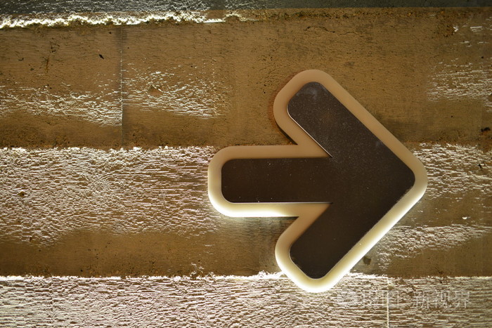 混凝土墙上的棕色箭头