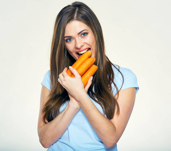 微笑的女人咬胡萝卜。隔离的室画像