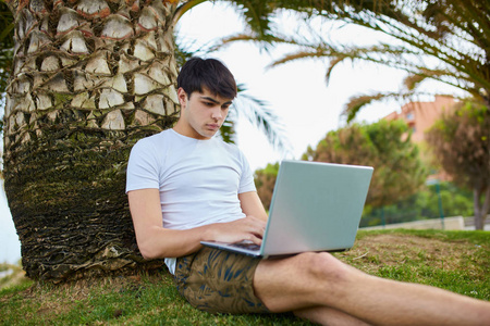 年轻男人放松外与笔记本电脑