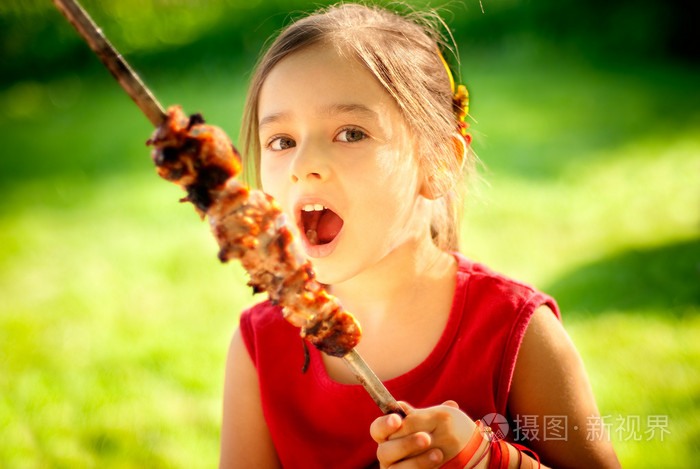 女孩吃烤肉串