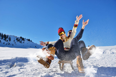 小两口滑雪橇和享受阳光明媚的冬日