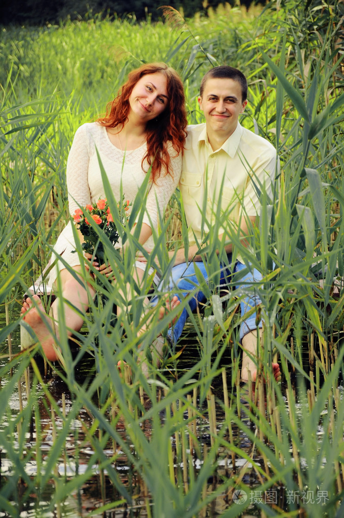 年轻的情侣拥抱在码头上