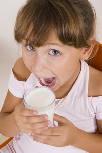 年轻的女孩与一杯牛奶