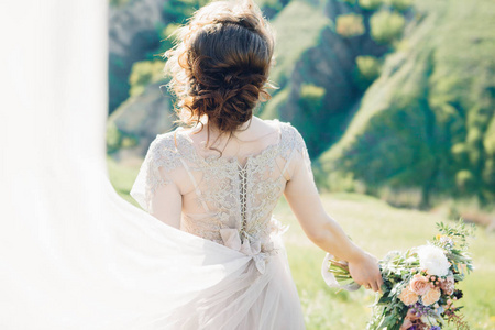 婚纱摄影美术。美丽的新娘花束与火车在自然中的衣服