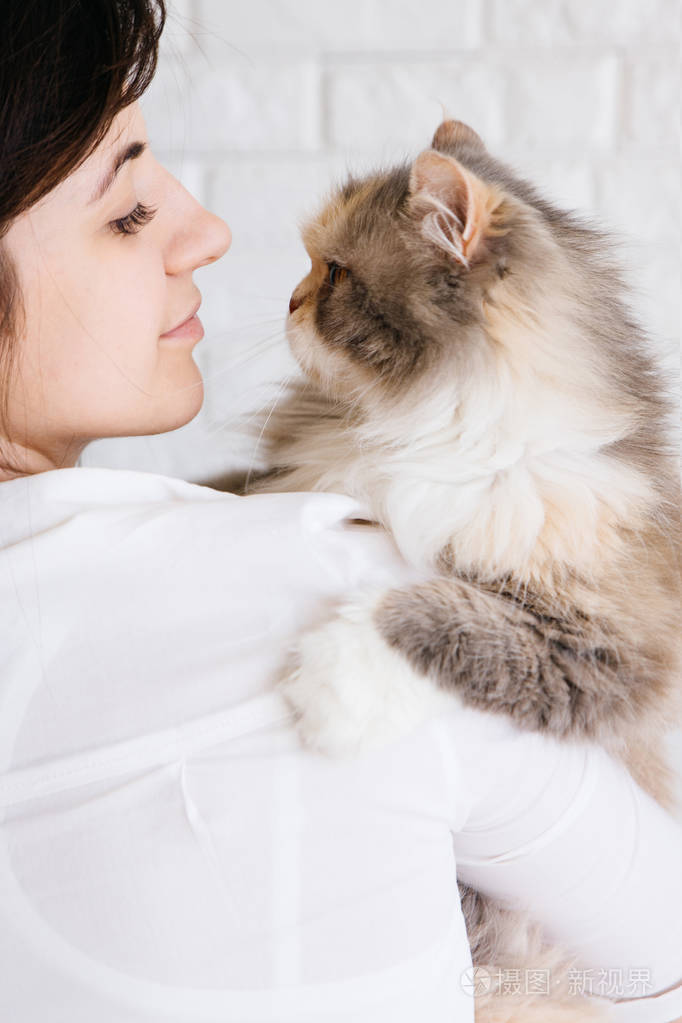 年轻女人手里拿着她毛茸茸的猫