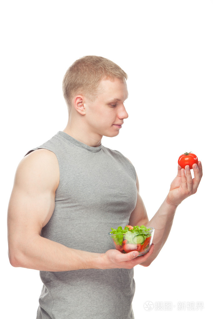 塑造和健康的身体男子抱着一个新鲜的沙拉碗,塑造腹部,白色背景的彩色