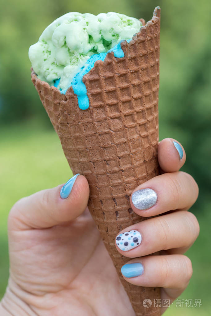 手中拿着一支冰淇淋甜筒