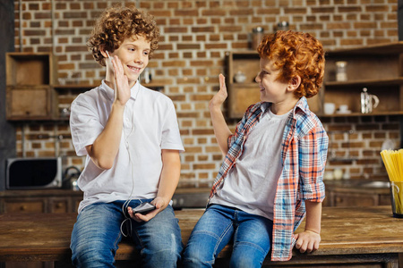 卷曲的头发兄弟击掌相庆在家照片