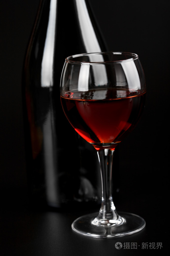 一杯红酒和一瓶黑葡萄酒
