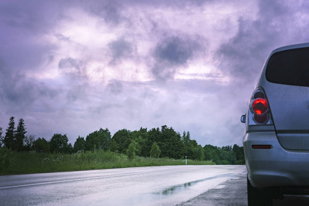 在一个暴风雨的天空下的道路上的汽车