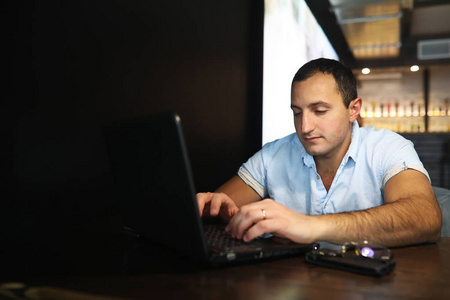 亚美尼亚英俊的男人，背后的笔记本电脑工作