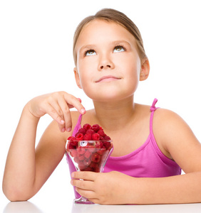 快乐的小女孩在吃树莓