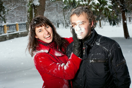 美丽的夫妇在雪地里玩耍