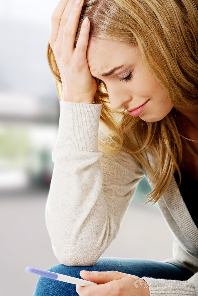 悲伤的年轻女子,持有怀孕测试照片-正版商用图片00dg68-摄图新视界
