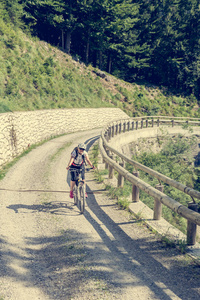 吸引女性骑自行车的人对付一条陡峭的路