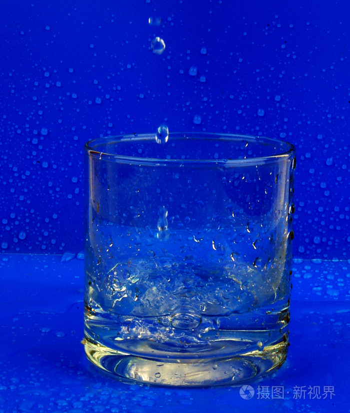 一杯水滴在黑暗的背上