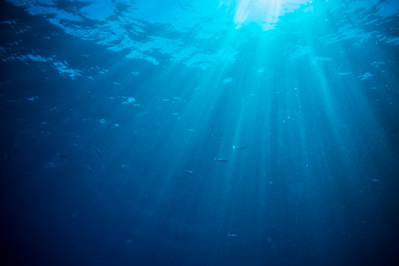 抽象的水下场景阳光和空气在深蓝色的大海中的泡沫照片