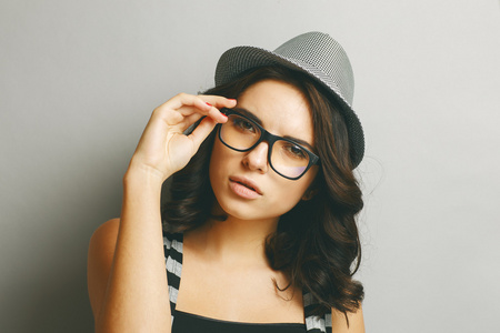 美丽的女孩在一顶帽子和眼镜