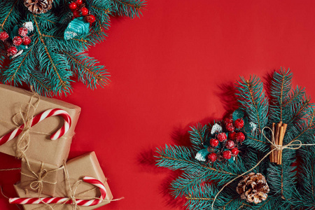 圣诞节组成的松果，云杉分行和堆栈的红色背景上的礼品盒